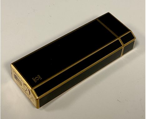 A Cartier gold plated and black enamelled rectangular cigarette lighter, tapered thumb edge,  registration number G42564, 7cm