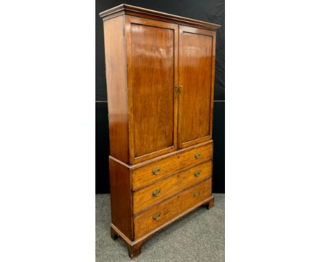 A George III mahogany bookcase on chest, having an outswept moulded cornice to the top, over a pair of panelled doors. The ba