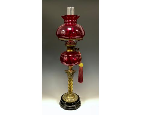 A Victorian style ruby glass and brass oil lamp, ruby reservoir and shade, spiralled column, black foot, 66cm high. 