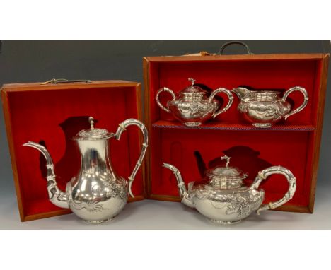 A Chinese silver four piece tea and coffee service, comprising teapot, coffee pot, milk jug and sucrier, each chased with a d