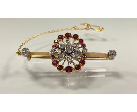 A diamond and ruby floral spray pendant, set with thirteen round brilliant and old cut diamonds and fourteen graduated pink a