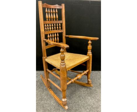 A Lancashire elm and ash ladder back rocking chair, rush seat, 114cm high x 62cm wide x 70cm deep. 