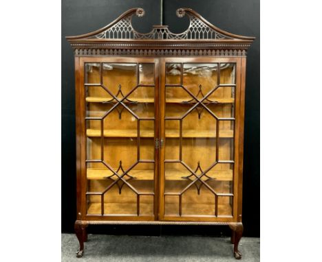 A large Chippendale Revival mahogany display cabinet, bold swan neck pediment pierced with Gothic tracery, above a dentil fri