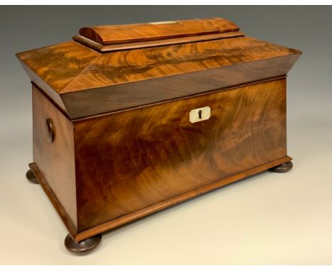 A Victorian Flame Mahogany Sarcophagus shaped tea caddy, mother-of-pearl escutcheon and inlaid panel to lid, bun feet, 21cm h