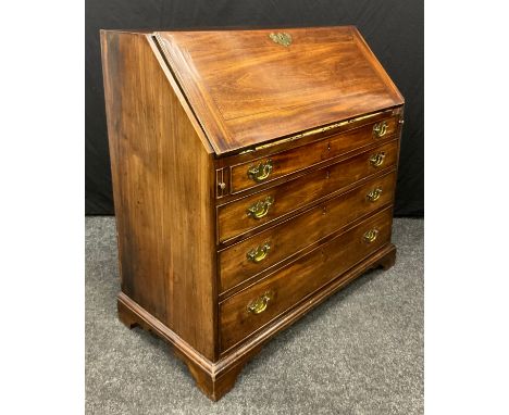 A George III mahogany bureau, fall front enclosing an arrangement of pigeon holes and small drawers centred by a compartment 