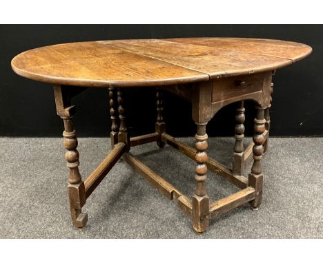 A George III oak drop-leaf dining table, the oval top of quarter-sawn oak with good figure, above a single drawer to frieze, 