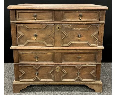 A William III oak chest, of split construction, oversailing top above four long drawers applied with geometric mouldings, ski