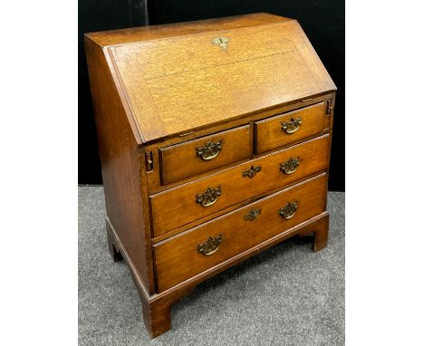 A George III oak bureau, of small proportions, fall door to top enclosing a fitted interior, with central small cupboard sect