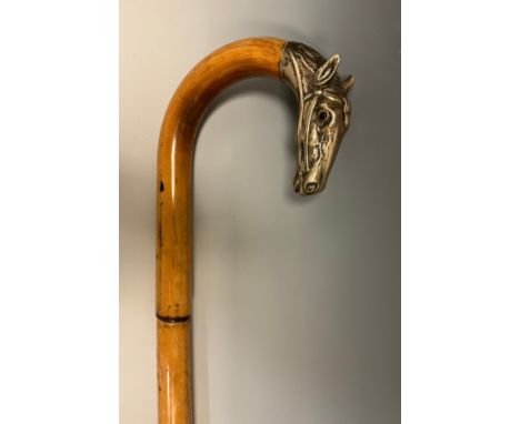 A late 19th century bamboo walking stick, the handle terminal cast in silver metal as the head of a race horse, glass eyes, 9