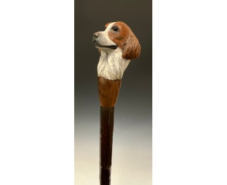 A carved wooden walking stick, by Mike Wood, the handle carved and painted as the head of a Spaniel, coppiced hazel stave, 14