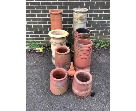 Eight assorted ceramic chimney pots and a finial, largest height 93cm. Condition - weathered