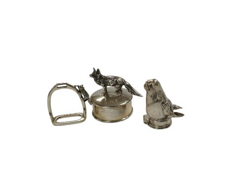 A George VI silver napkin ring modelled as a stirrup, surmounted with a fox, Birmingham, 1937, 46mm, together with a later si