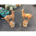 A pair of cast iron finials as deer standing upon spheres, height 92cm. Condition - weathered