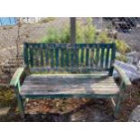 A green painted teak garden bench, width 138cm. Condition - weathered, otherwise fair