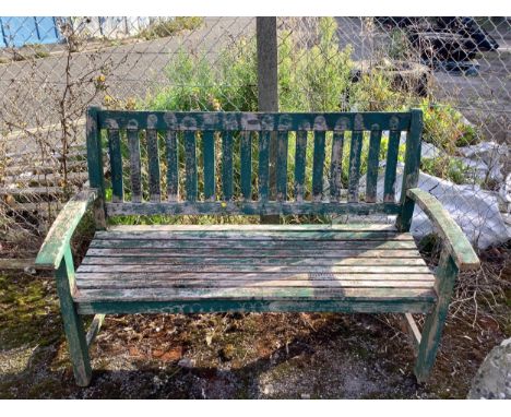 A green painted teak garden bench, width 138cm. Condition - weathered, otherwise fair