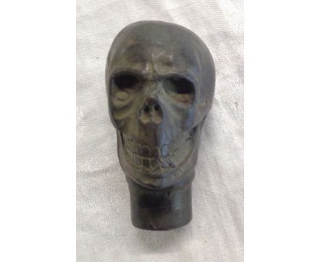 A brass walking stick finial in the form of a human skull