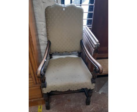 A 20th Century polished oak part show frame open armchair with remains of studded repeat pattern tapestry upholstery, set on 
