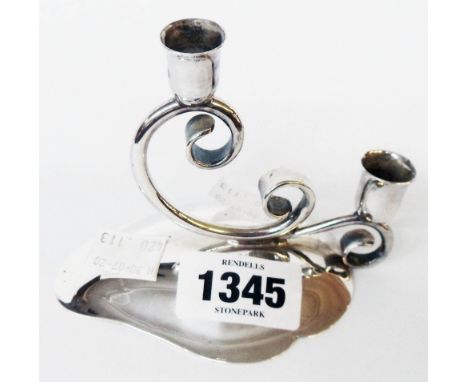A Danish white metal twin branch taper candlestick with scroll support and leaf shaped base, by C. H. R. Jensen