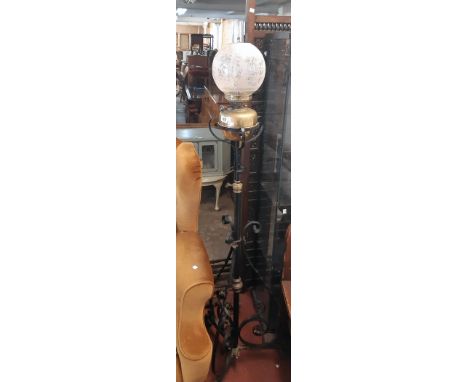 A late Victorian ornate wrought iron and brass telescopic oil lamp standard with chimney and etched globe