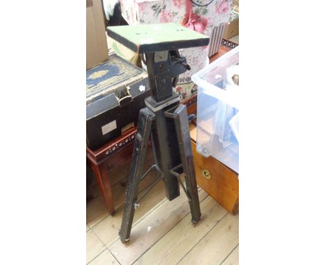 A vintage Gandolfi photographic tripod with hand wind height adjuster