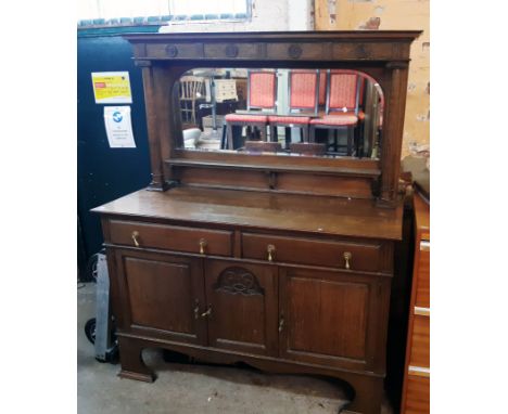 A 5' 1/2" early 20th Century polished oak mirror backed sideboard with domed mirror plate and shelf with flanking pillars ove