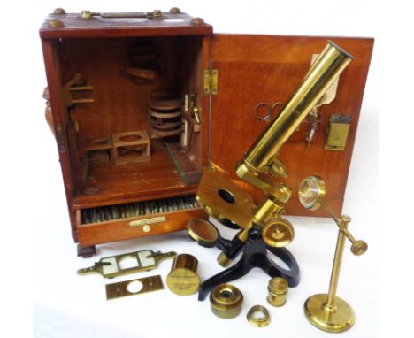 A late 19th to early 20th Century compound microscope on shaped tripod base in the 'Crouch foot' manner, in wooden case with 