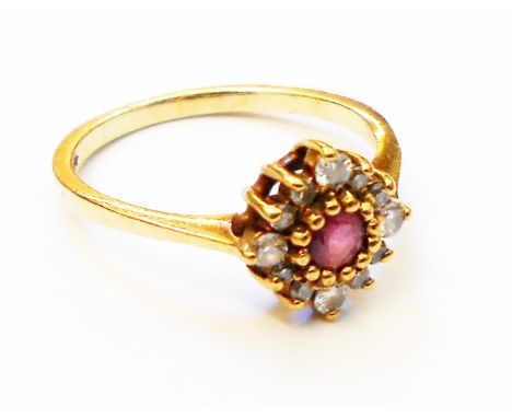 A hallmarked 375 gold ring, set with central small ruby within a diamond encrusted border