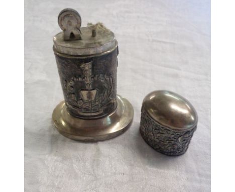 An antique white metal table lighter with eagle over a book motif within ornate decoration