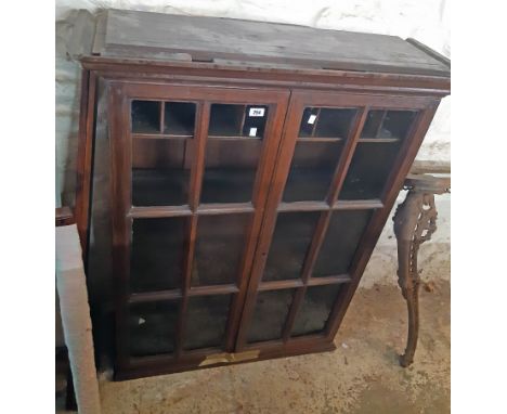 A 3' 3 1/2" antique stained oak book cabinet with pigeon-hole and shelf fitted interior enclosed by a pair of glazed panel do