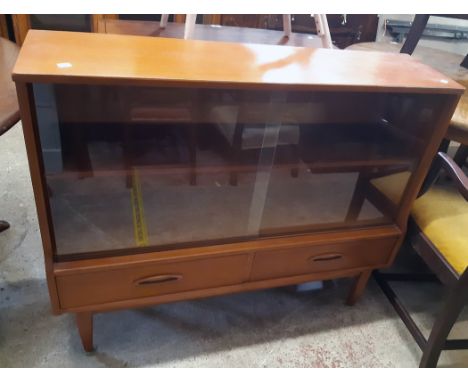 A 3' 6" retro teak effect book cabinet with adjustable shelf enclosed by a pair of glass sliding doors and with two drawers u