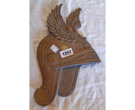 A vintage cast brass wall plaque in the form of a winged helmet - serial number to reverse