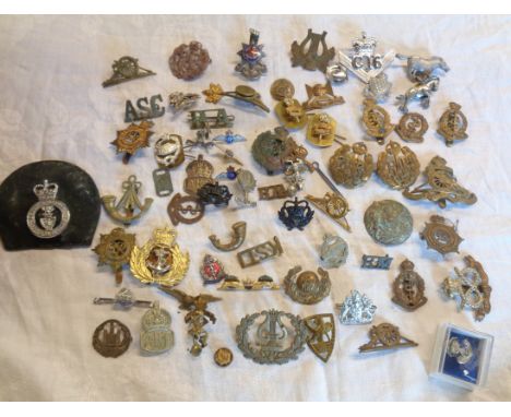 A collection of military and other cap badges including The Royal Sussex Regiment, ARP, vintage Ford Mustang style pin badge,