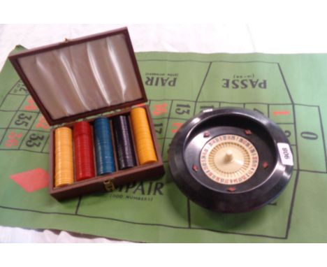 A vintage roulette game including wheel, mat, and boxed set of chips