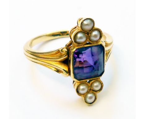 An Edwardian style yellow metal ring, set with central amethyst and six flanking seed pearls