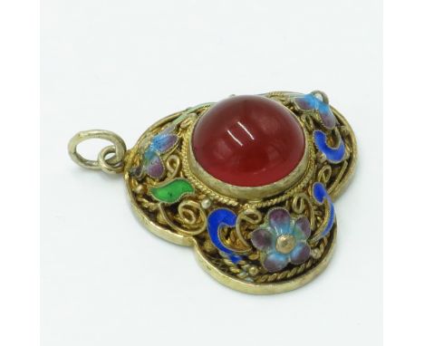 A Chinese silver gilt filigree trefoil pendant with central carnelian surrounded by scroll work and floral enamel.