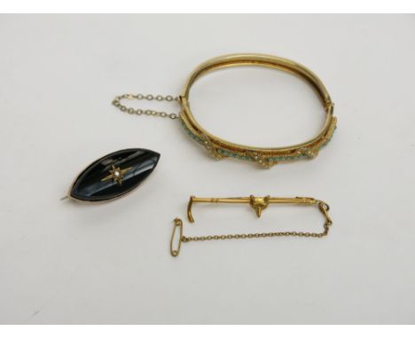 A Victorian gold mounted onyx brooch, a 9ct gold hunting brooch and a gilt hinged bangle.