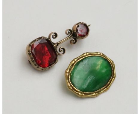 A gold brooch set with red stones and gold mounted cufflink element set with jade.