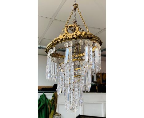 A gilt brass and glass chandelier, 1920s, the upper tier with wreath and floral garland decoration with spear drops and two f