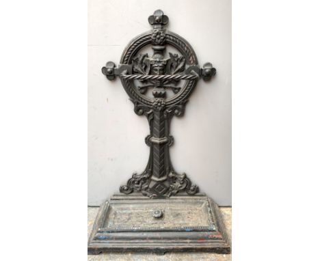 A cast iron stick stand, 19th century, cast with a female mask to the Gothic style roundel and with a removable drip tray, wi