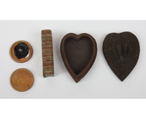 An 18th century heart shaped small chip carved box together with a book form snuff box and a treen seal case containing a rel