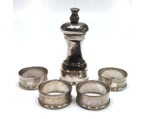 A solid silver pepper mill with thistle finial, Sheffield hallmarks together with a set of four silver napkin rings, 7.7oz.