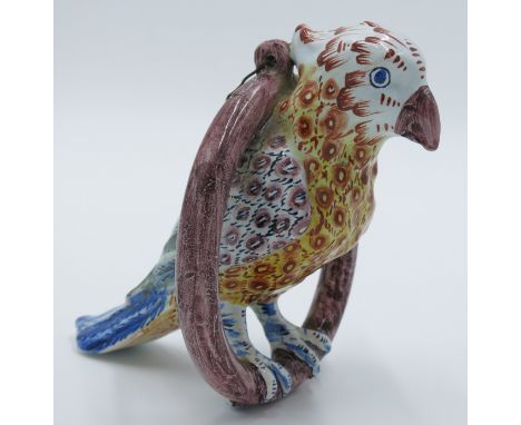 A Delft pottery figure of a parrot on a ring perch, possibly by Adrianus Kocks, polychrome decorated, monogrammed AK, height 