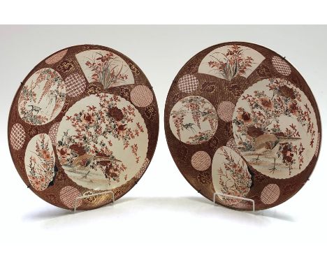 A pair of Japanese satsuma chargers, 19th century, each decorated with panels enclosing floral sprays and birds, signed, diam