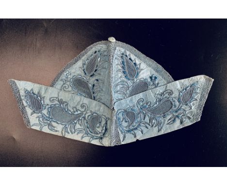 Gentleman's undress cap, mid 18th century. Lavishly embroidered foliate designs on blue silk with panels of openwork, the cap