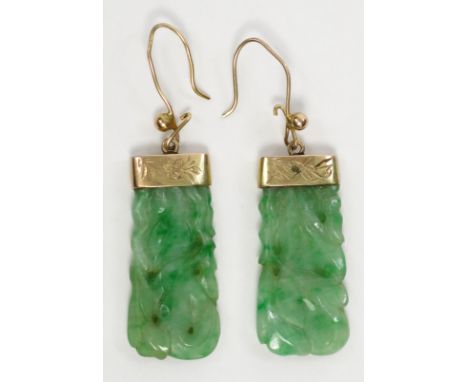 A pair of gold mounted carved jade earrings.