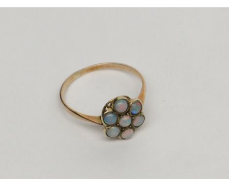 A gold ring set with an opal cluster.