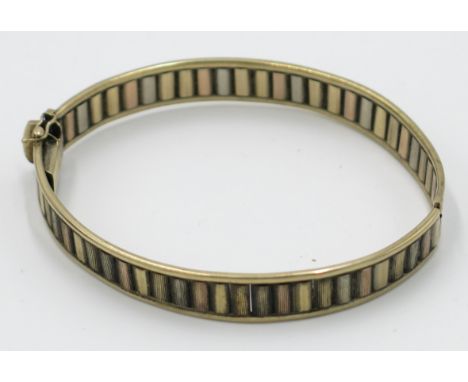 A 9 ct. multicoloured gold hinged bangle, 16 g.