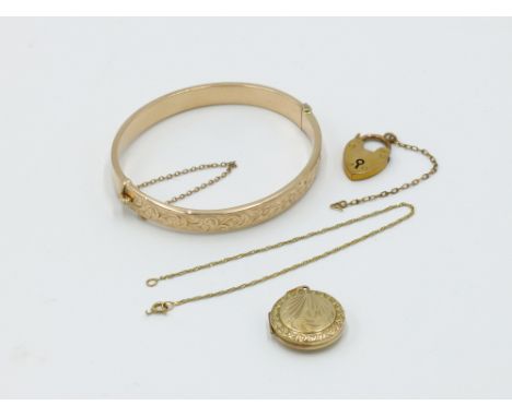 A 9ct gold locket, a fine gold chain with padlock clasp, a fine gold bracelet, a gold padlock clasp and a gold hinged bangle 