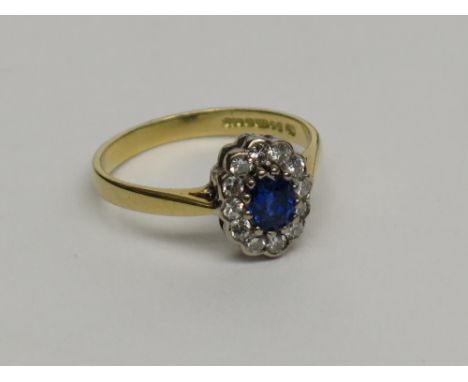 A sapphire and diamond oval cluster ring set in 18ct gold.