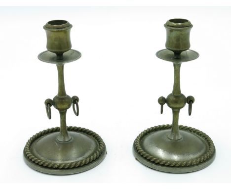 A pair of brass candlesticks, the knopped stems with ring drops, on circular bases with gadrooned edges, height 17cm.